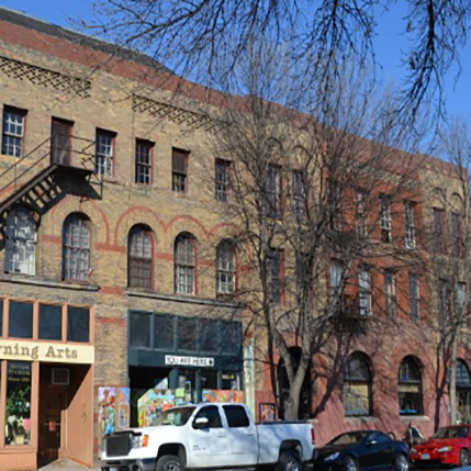 Outside the Odd Fellows Apartment building. An old building downtown above a coffee shop. Arches and red and brown brick on the outside.