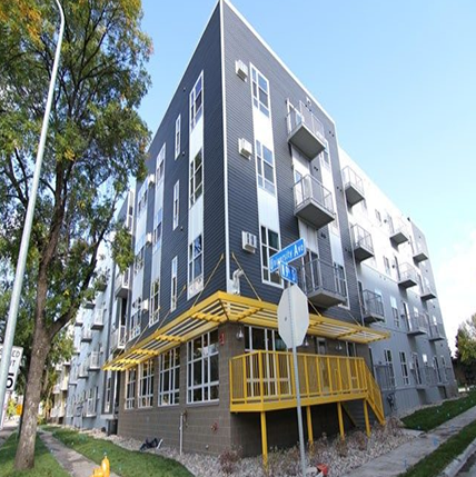 University Flats Grand Forks exterior. Multishades of gray on the outside sidig. Lots of windows and Yellow metal steps into the entrance.