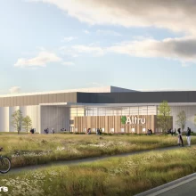 JLG Renderings of the new altru sports complex being built. It is set in a field surrounded by tall grasses and has tall windows surrounding the exterior.