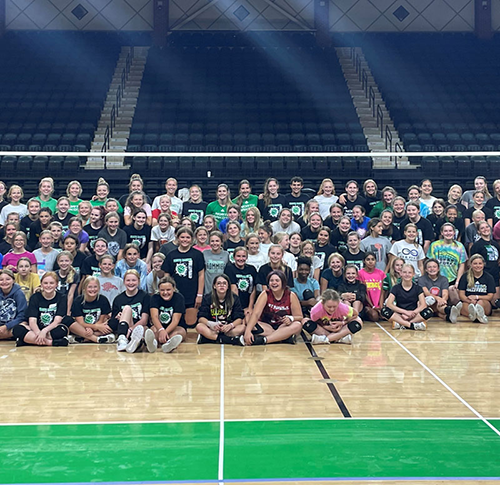 The entire group for UND Volleyball camp stands together for a photo inside the gym