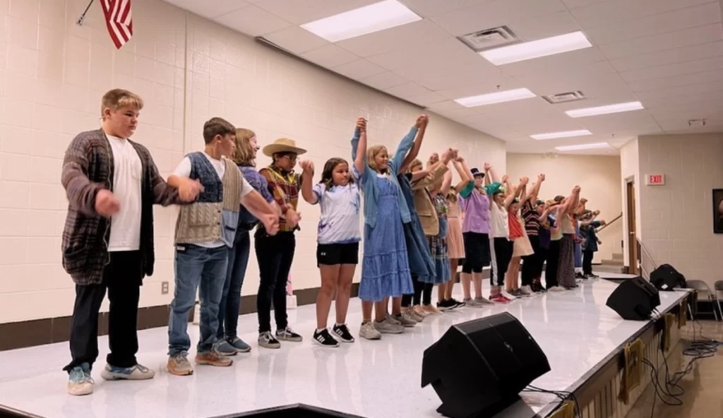 Stages Summer Camp kids are in the process of bowing on the stage.