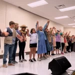 Stages Summer Camp kids are in the process of bowing on the stage.