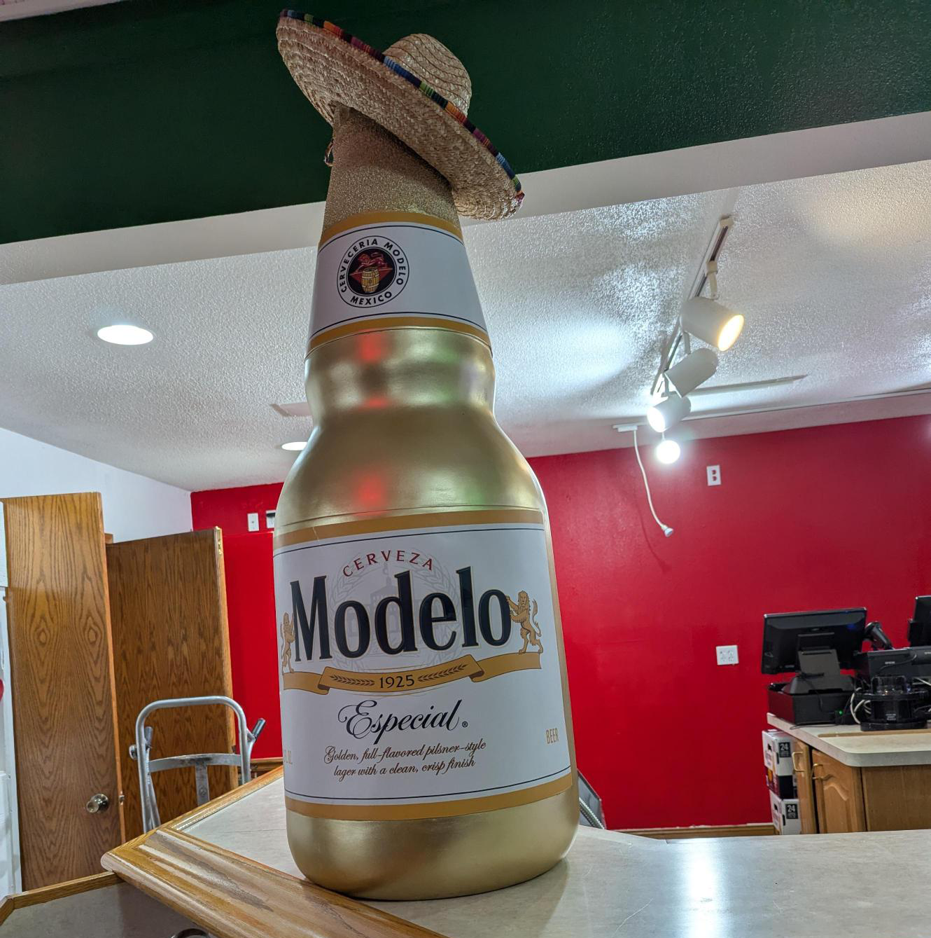 Modelo bottle with a sombrero A photo inside Las Delicias de la Abuela of a giant statue of a Modelo bottle wearing a sombrero.