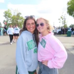 Author Lauren in the pink sweatshirt poses with a friend at the UND Tailgate