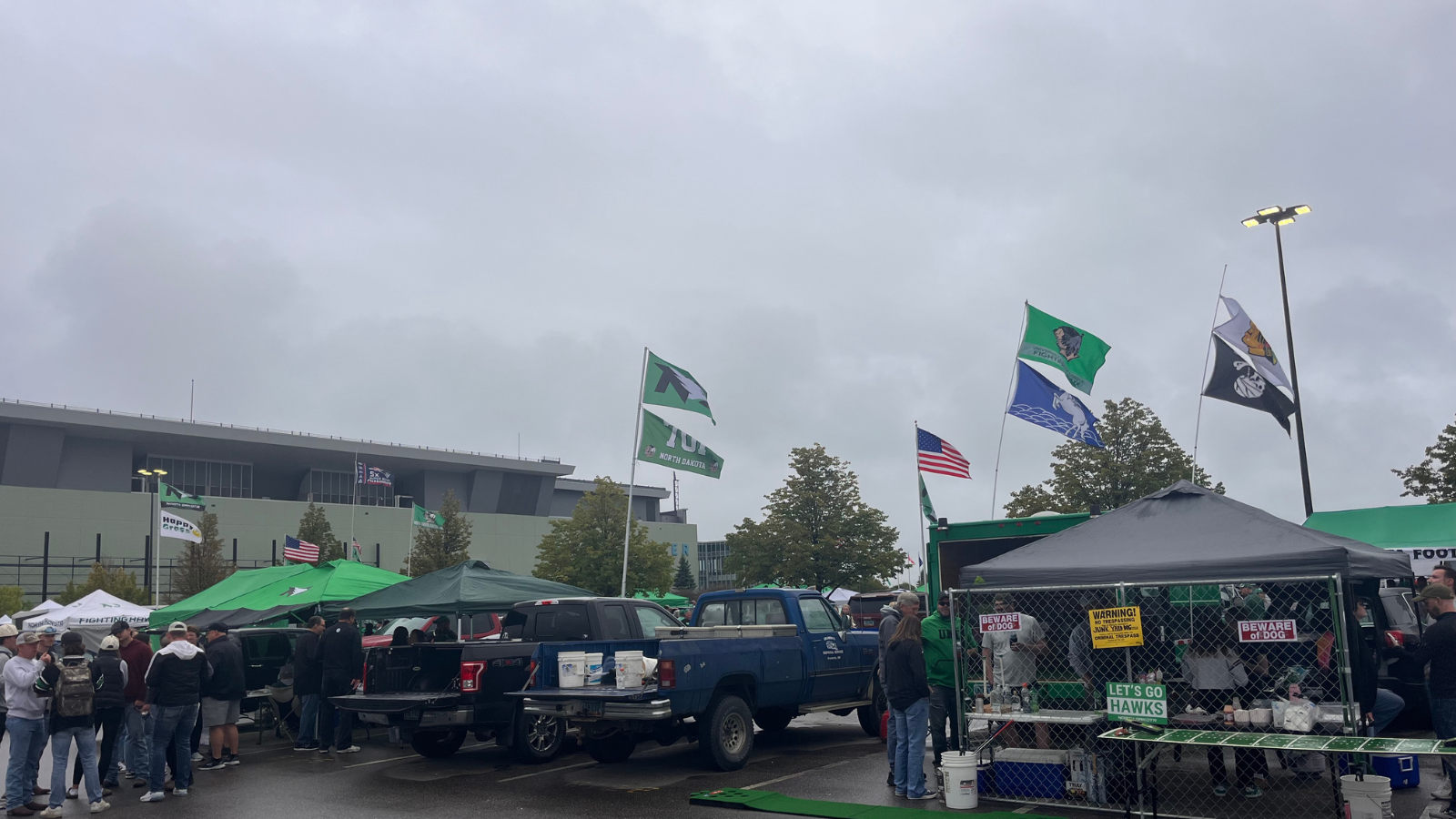 UND Tailgate photo with many flags for UND flying in the photo. The Alerus is in the background.