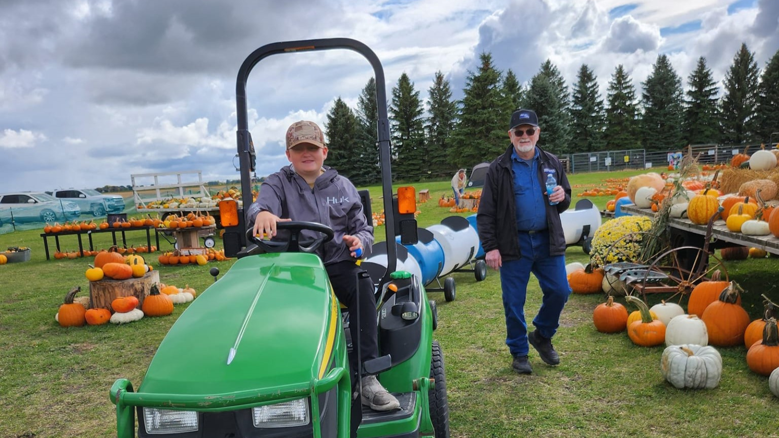 Patch on the point tractor train pictured with a bunch of pumpkins surrounding the path of various colors.