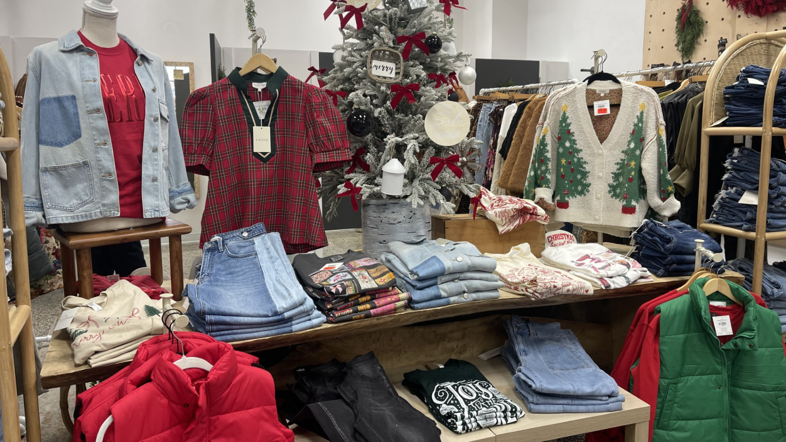 The Silo boutique Christmas display with red and green accented pieces. Light wash jeans and puffer vests too!