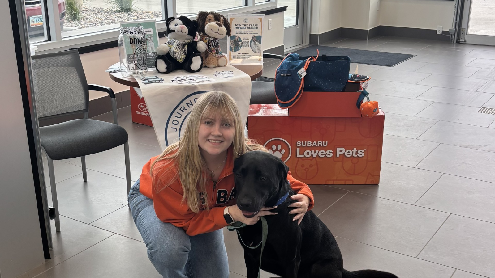 Madi Journey Home Photo Author Madi poses crouched down with a black lab while volunteering with Journey Home Animal Rescue