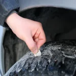 Author Eli demonstrates using a coin to check tire tread width!