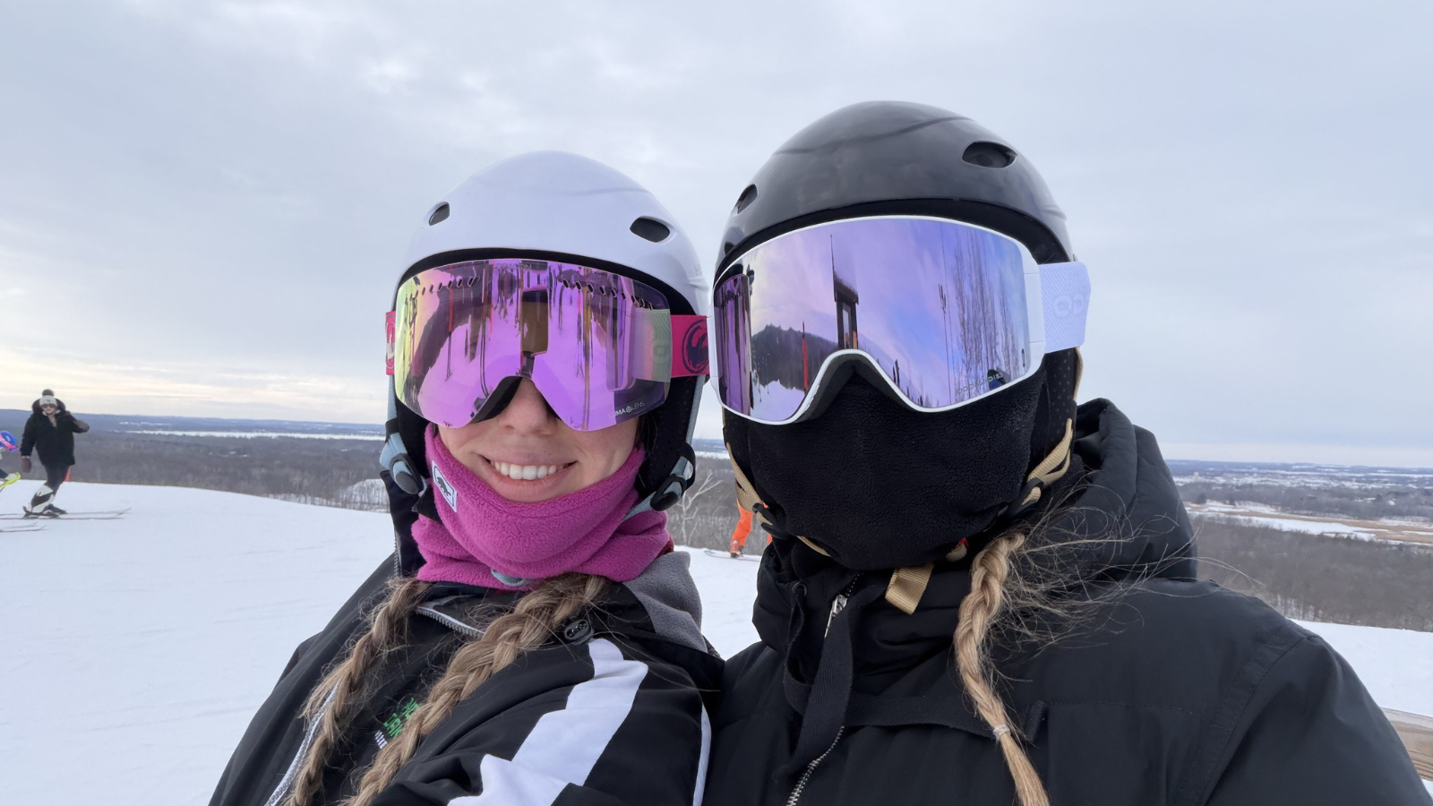 Selfie Skiing Photo Two women face the camera on the top of Detroit Mountain for a selfie. They have their goggles and masks on with their braids coming out the front.
