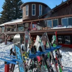 Pictured is Frostfire Park Ski Lodge with the ski racks full and the sun shining down.
