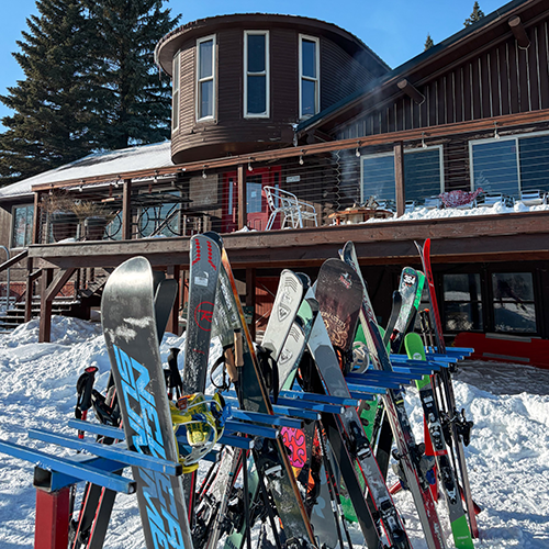 Pictured is Frostfire Park Ski Lodge with the ski racks full and the sun shining down.