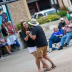 A couple is pictured dancing together in town square