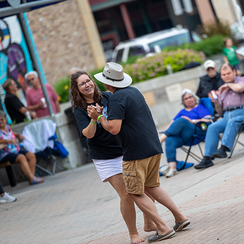 A couple is pictured dancing together in town square