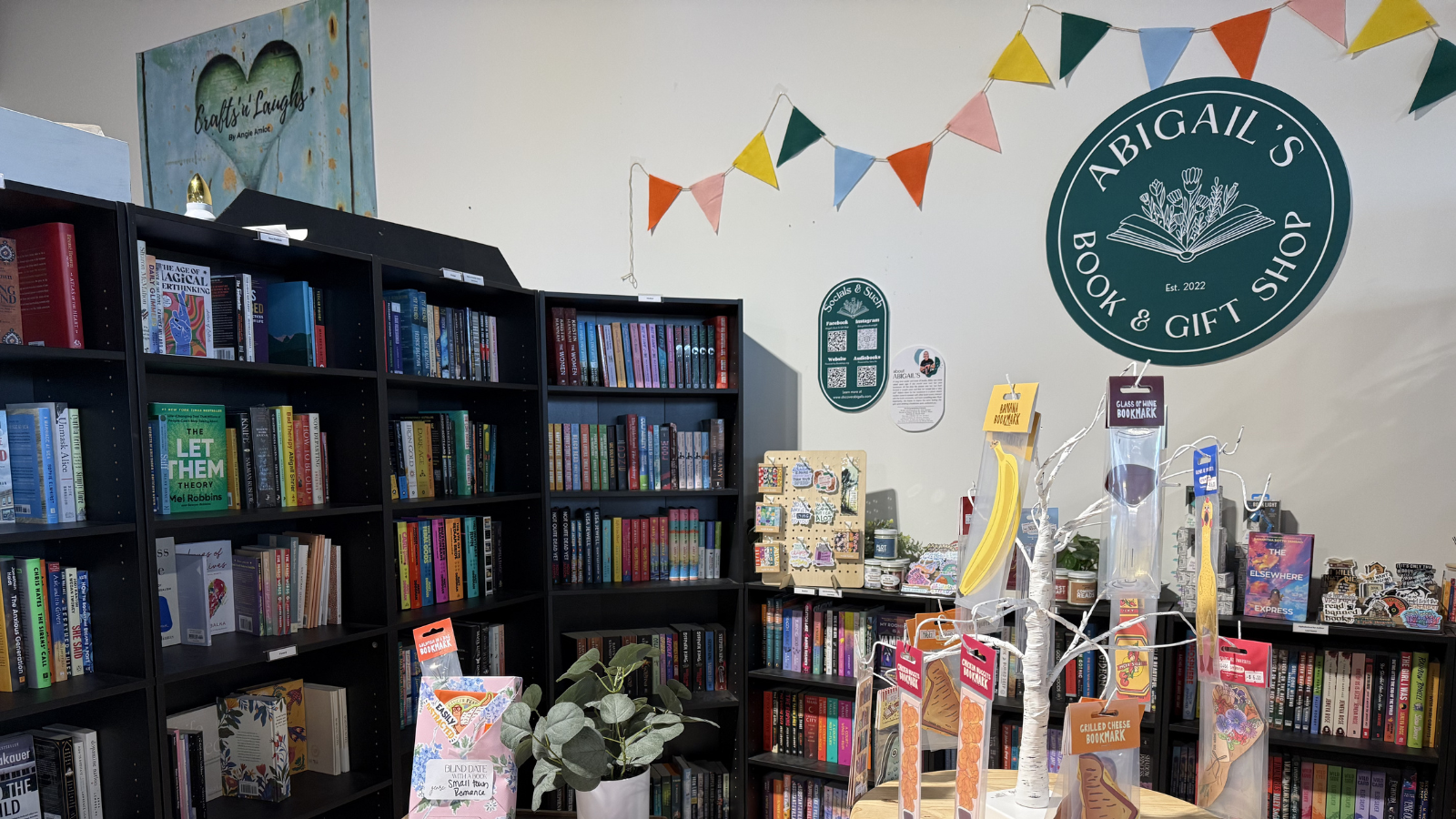 Picture of Abigail's bookstore booth in Midtown Marketplace, showing her full shelves and cute decorations.