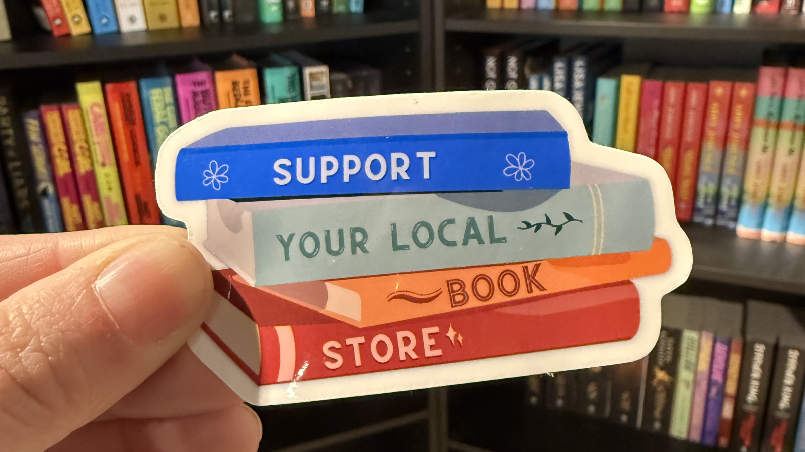 A close up photo of a sticker for supporting local book stores!