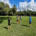 Kids playing together in a field in the summertime