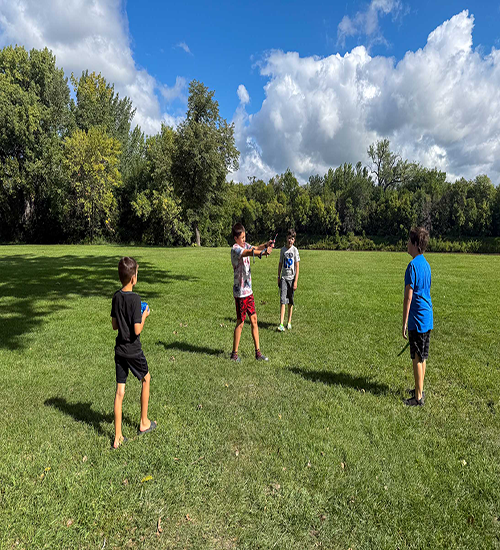 Kids playing together in a field in the summertime