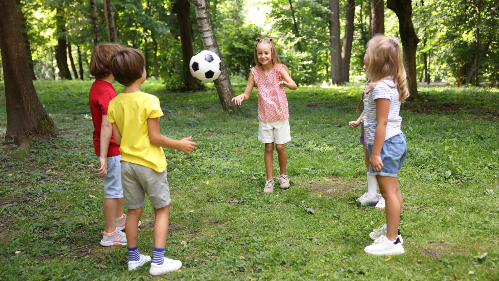 Kids playing ball together Kids playing games together out in the forest in the summertime