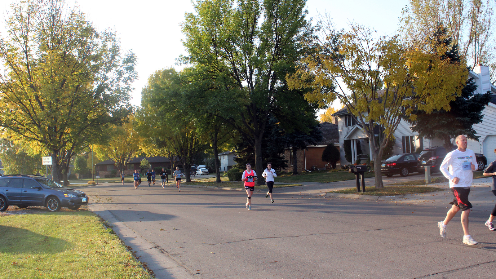 A group of runners in a race comes through a Grand Forks neighborhood in the late summertime