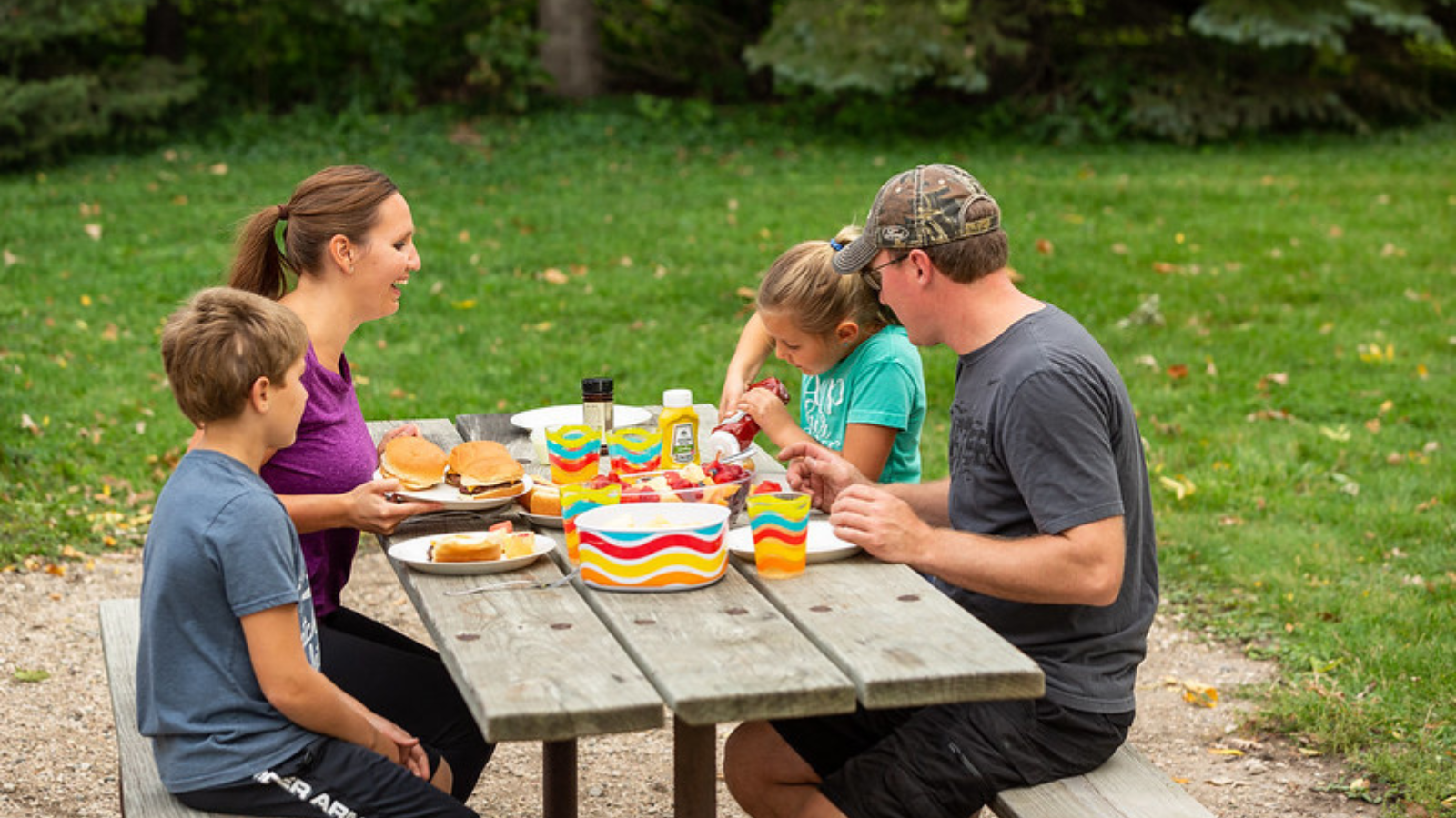 A family sits at a picnic table at Turtle River State Park in Grand Forks for a bite to eat